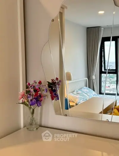 Chic bedroom with stylish mirror and city view, perfect for modern living.