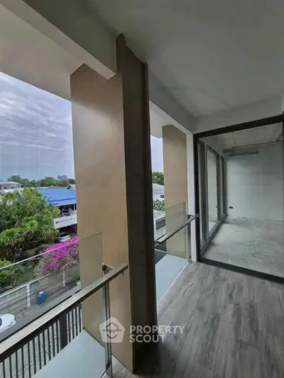 Spacious balcony with modern glass railing and scenic view, perfect for relaxation and enjoying the outdoors.