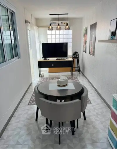 Modern living room with stylish decor and dining area in compact space.