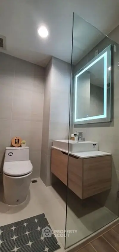 Modern bathroom with glass shower and illuminated mirror