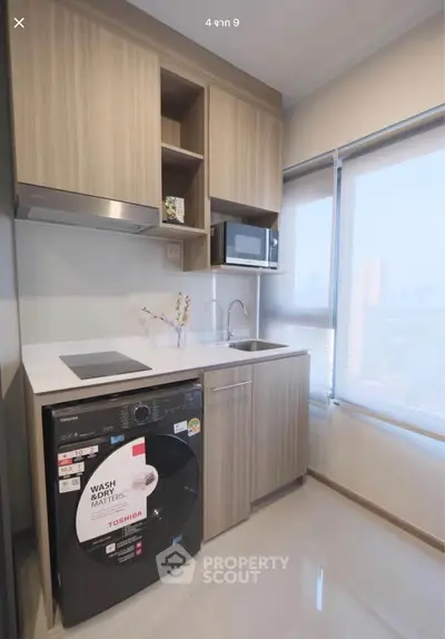 Modern kitchen with built-in appliances and city view, featuring sleek cabinetry and compact design.