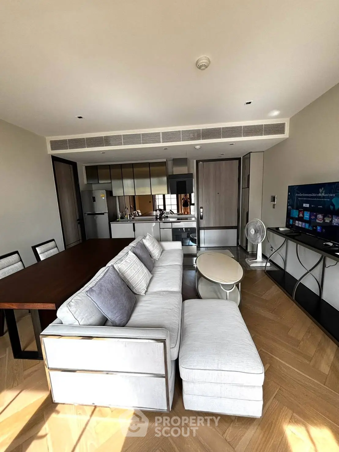 Modern living room with open kitchen, stylish furniture, and natural light