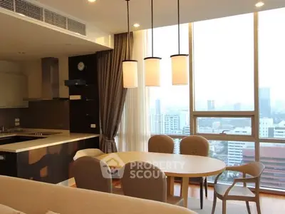 Modern open-layout kitchen and dining area with city view, featuring sleek design and ample natural light.
