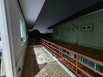 Spacious balcony with wooden railing offering serene night views in a modern residential building.