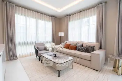 Elegant living room with modern furniture and large windows, featuring a cozy sofa and stylish decor.