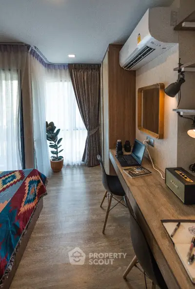 Modern bedroom with study area, featuring stylish decor and natural light.
