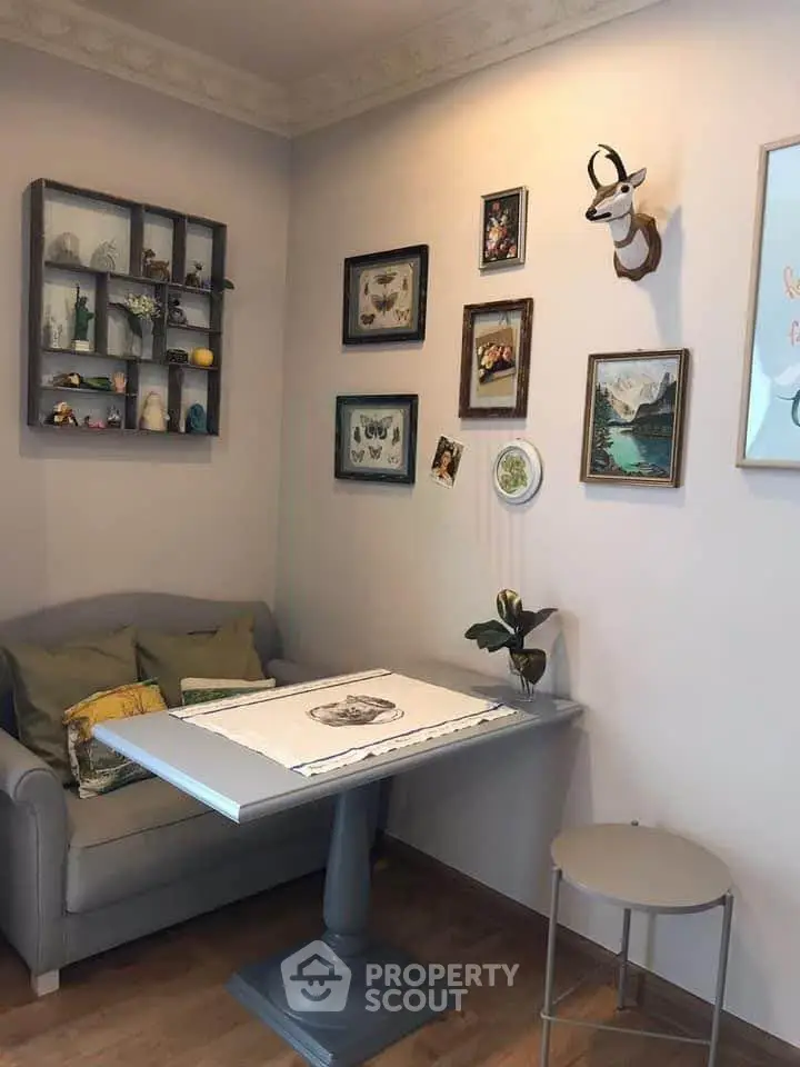 Charming living room corner with cozy sofa, decorative wall art, and stylish table, perfect for relaxation.