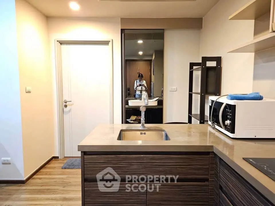 Modern kitchen with sleek design, featuring a built-in sink and microwave, perfect for urban living.