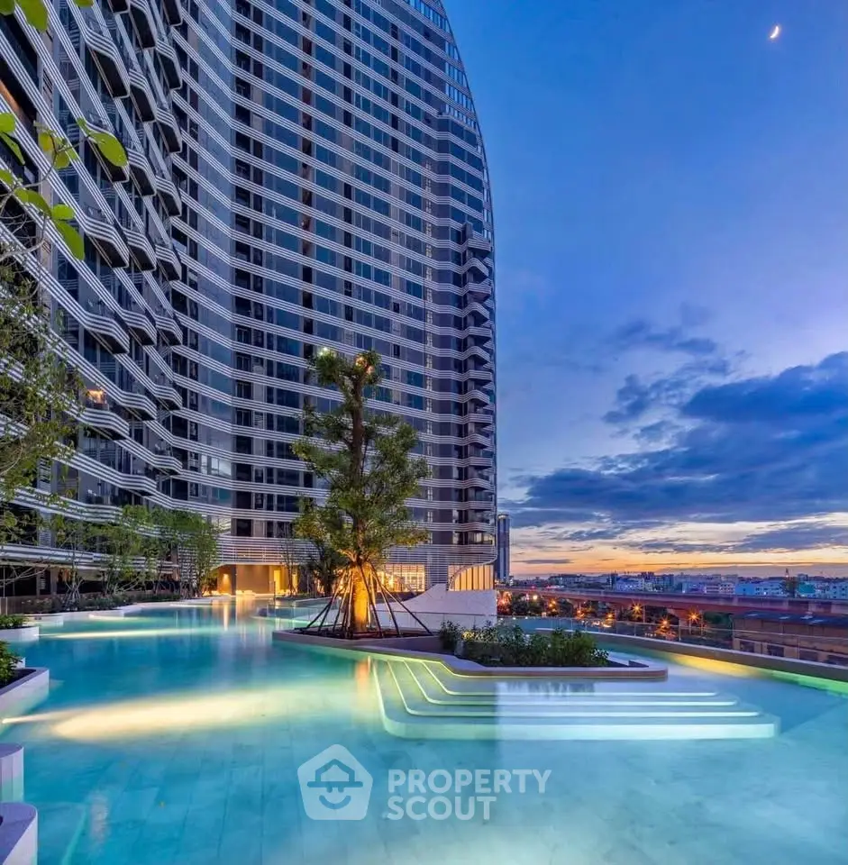Luxurious high-rise building with stunning rooftop pool and panoramic city views at sunset.