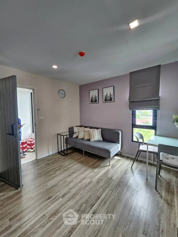Modern living room with stylish decor and natural light, featuring a cozy sofa and dining area.