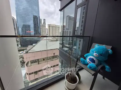 Modern balcony with city view and plush toy, perfect for relaxation in urban setting.