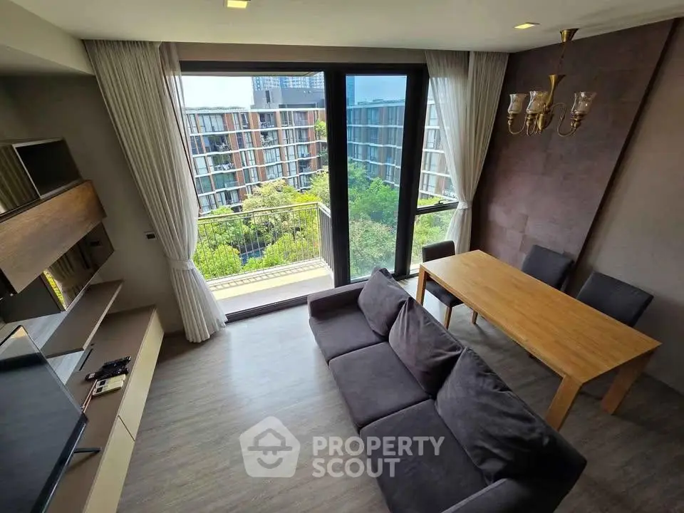 Modern living room with large windows and a view of the cityscape, featuring elegant furniture and natural light.