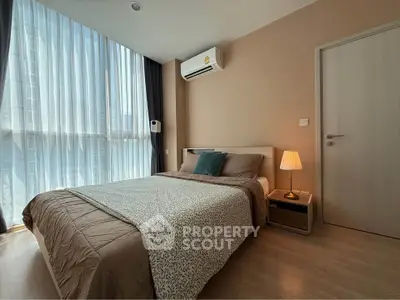Cozy modern bedroom with large window and stylish decor in a contemporary apartment.