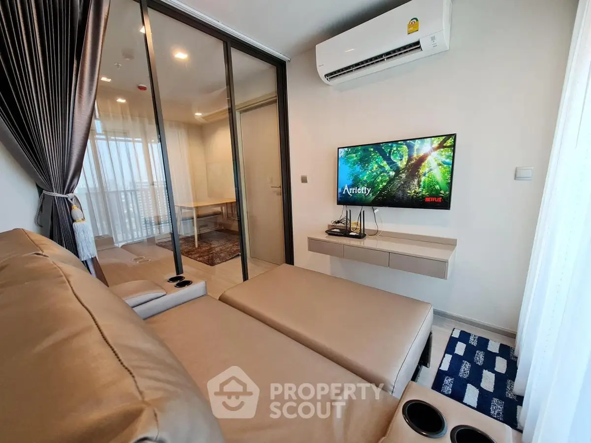 Modern living room with sleek design, featuring a wall-mounted TV and comfortable seating, perfect for relaxation.