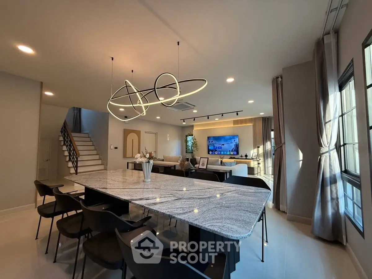 Modern open-plan living room with stylish lighting and elegant dining area