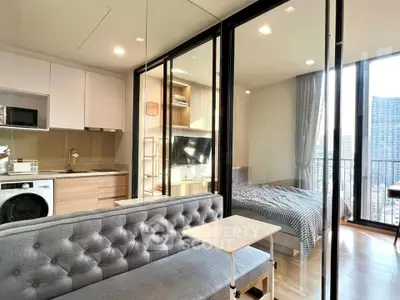 Modern studio apartment with glass partition, cozy living area, and city view balcony.