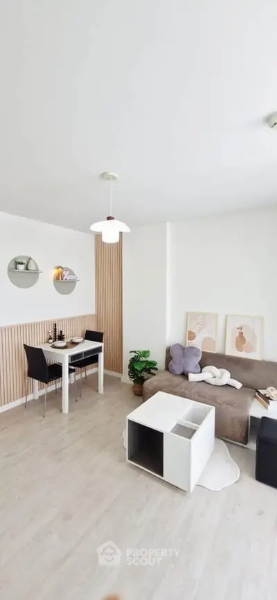 Modern living room with stylish decor and dining area, featuring minimalist furniture and elegant lighting.