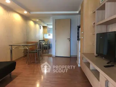 Modern living room with wooden flooring, sleek furniture, and ambient lighting in a stylish apartment.