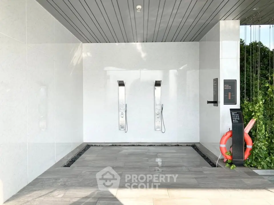 Modern outdoor shower area with sleek design and greenery, perfect for luxury living.