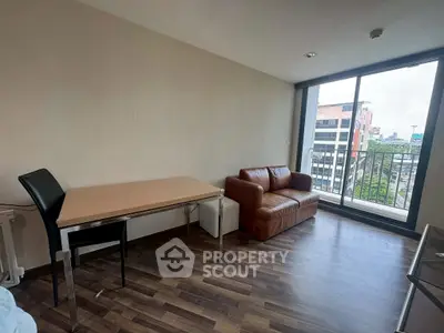 Modern living room with city view, featuring sleek furniture and large windows for natural light.