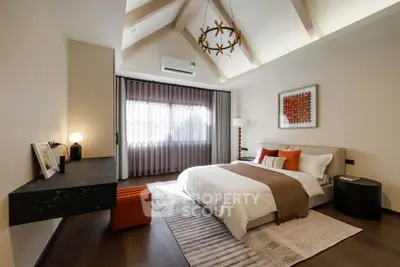 Luxurious bedroom with vaulted ceiling and modern decor, featuring a cozy bed and stylish lighting.
