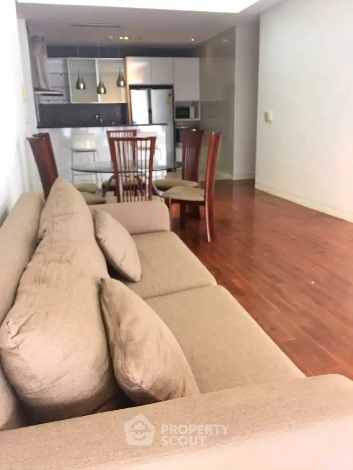 Spacious open-plan living room with modern kitchen and elegant wooden flooring.