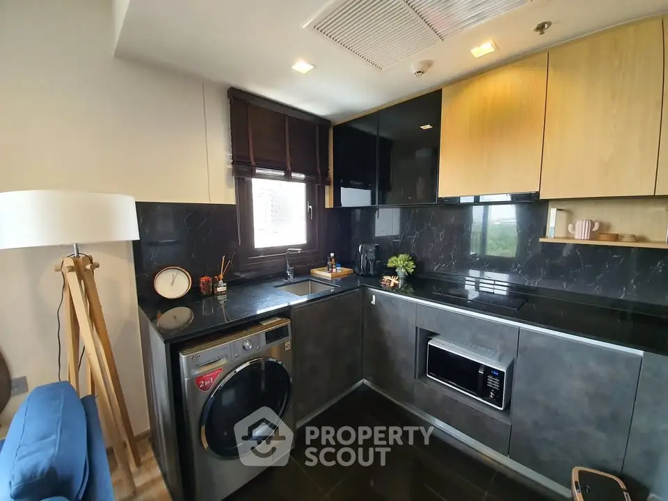 Modern kitchen with sleek black countertops, built-in appliances, and stylish cabinetry.