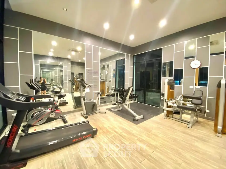 Modern gym with state-of-the-art fitness equipment and mirrored walls.