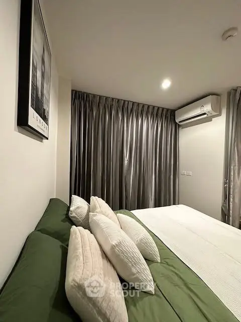 Cozy bedroom with modern decor and air conditioning, featuring elegant curtains and stylish bedding.