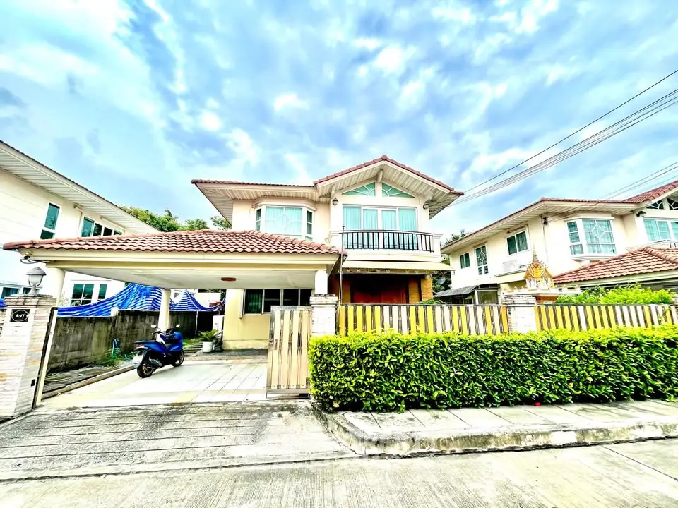 Charming suburban house with red-tiled roof and lush greenery, perfect family home in a peaceful neighborhood.