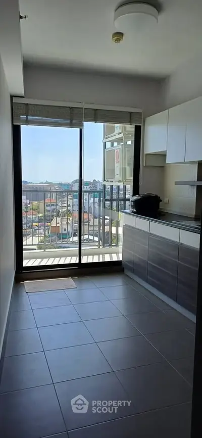 Modern kitchen with balcony view in a high-rise apartment