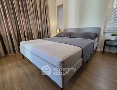 Cozy bedroom with elegant decor and natural light, featuring a comfortable bed and stylish curtains.