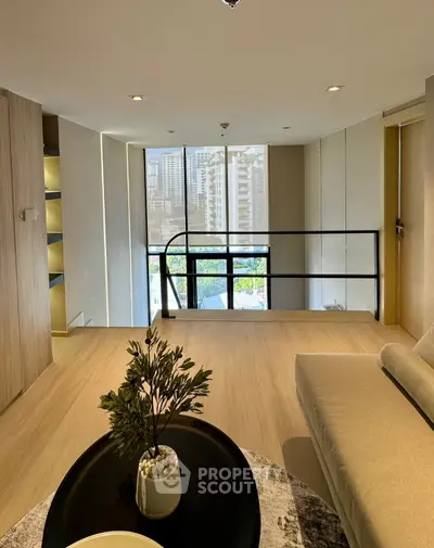 Modern living room with city view, featuring sleek design and cozy seating area.