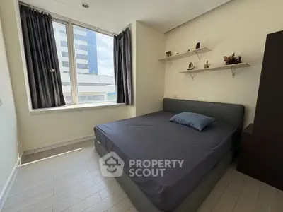 Modern bedroom with large window and minimalist decor in urban apartment.