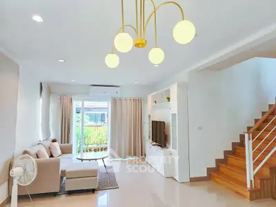 Modern living room with stylish lighting and cozy seating area in a bright open space.