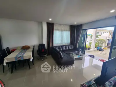 Spacious modern living room with sleek furniture and large windows offering natural light.