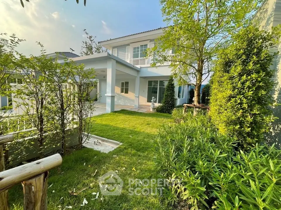 Charming two-story house with lush garden and spacious patio, perfect for outdoor relaxation.