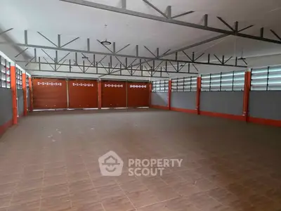 Spacious industrial warehouse with high ceilings and ample natural light.