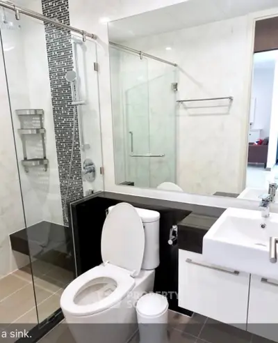 Modern bathroom with glass shower and sleek fixtures in contemporary apartment.