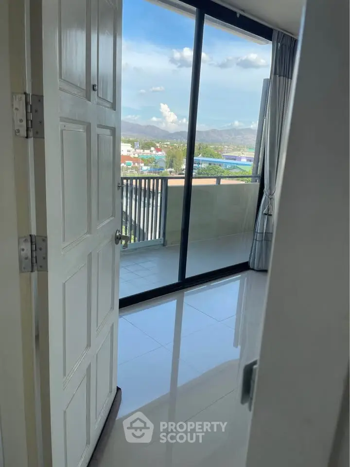 Spacious room with balcony offering stunning mountain views and abundant natural light.