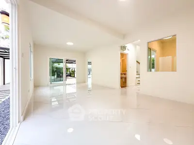Spacious modern living room with glossy white floors and large windows