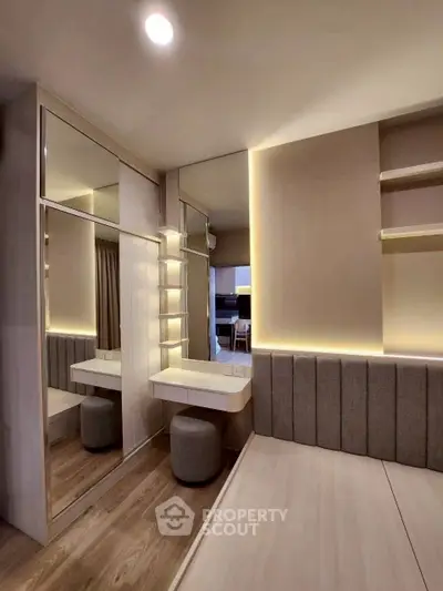 Modern bedroom with elegant lighting and mirrored wardrobe in a stylish apartment.