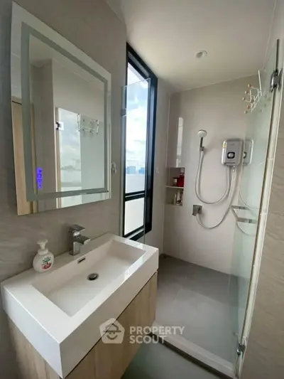 Modern bathroom with sleek shower and stylish vanity in a high-rise apartment.