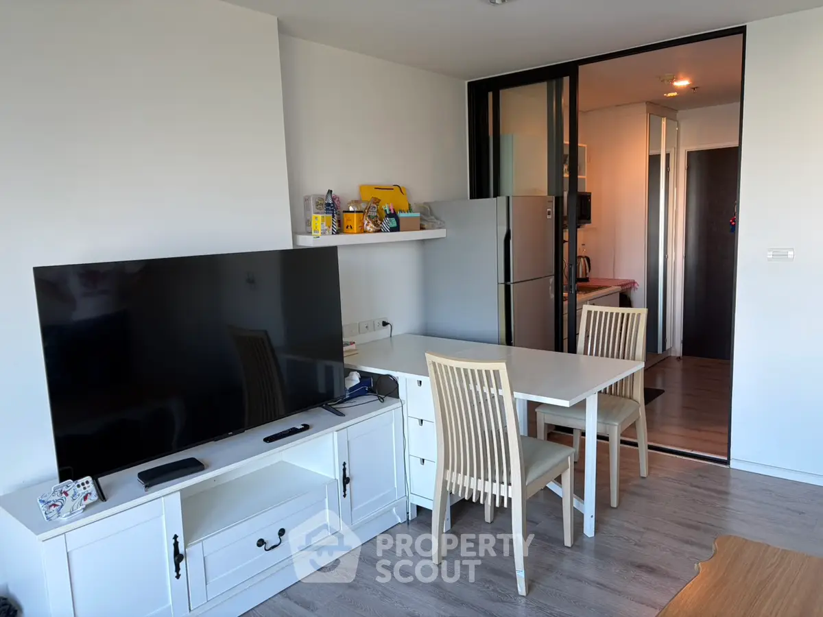 Modern living room with sleek TV and dining area, featuring a stylish open layout and contemporary decor.