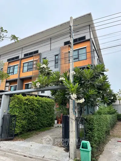 Modern townhouse with stylish facade and lush greenery in a serene neighborhood.