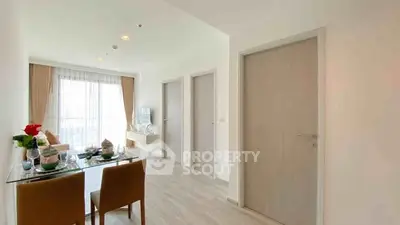 Modern living room with dining area and natural light, featuring elegant decor and wooden flooring.