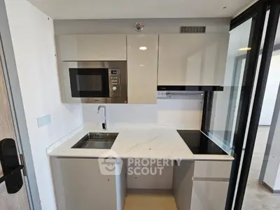 Sleek modern kitchen with built-in stainless steel appliances, ample countertop space, and a minimalist design ideal for urban living.