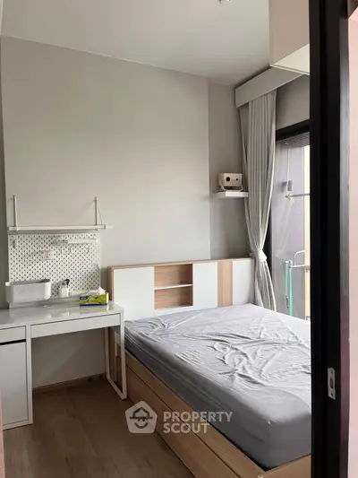 Modern bedroom with sleek design, featuring a cozy bed and functional workspace, perfect for urban living.