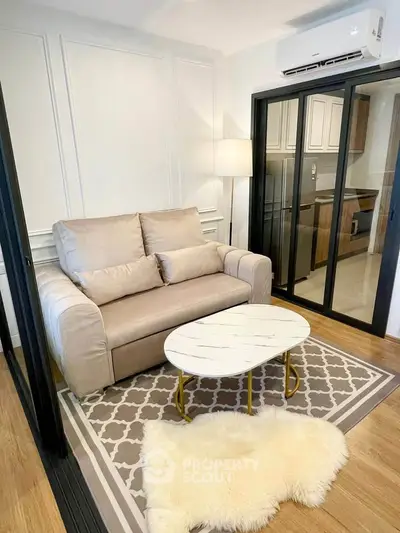 Modern living room with stylish decor and sliding glass doors leading to a sleek kitchen.