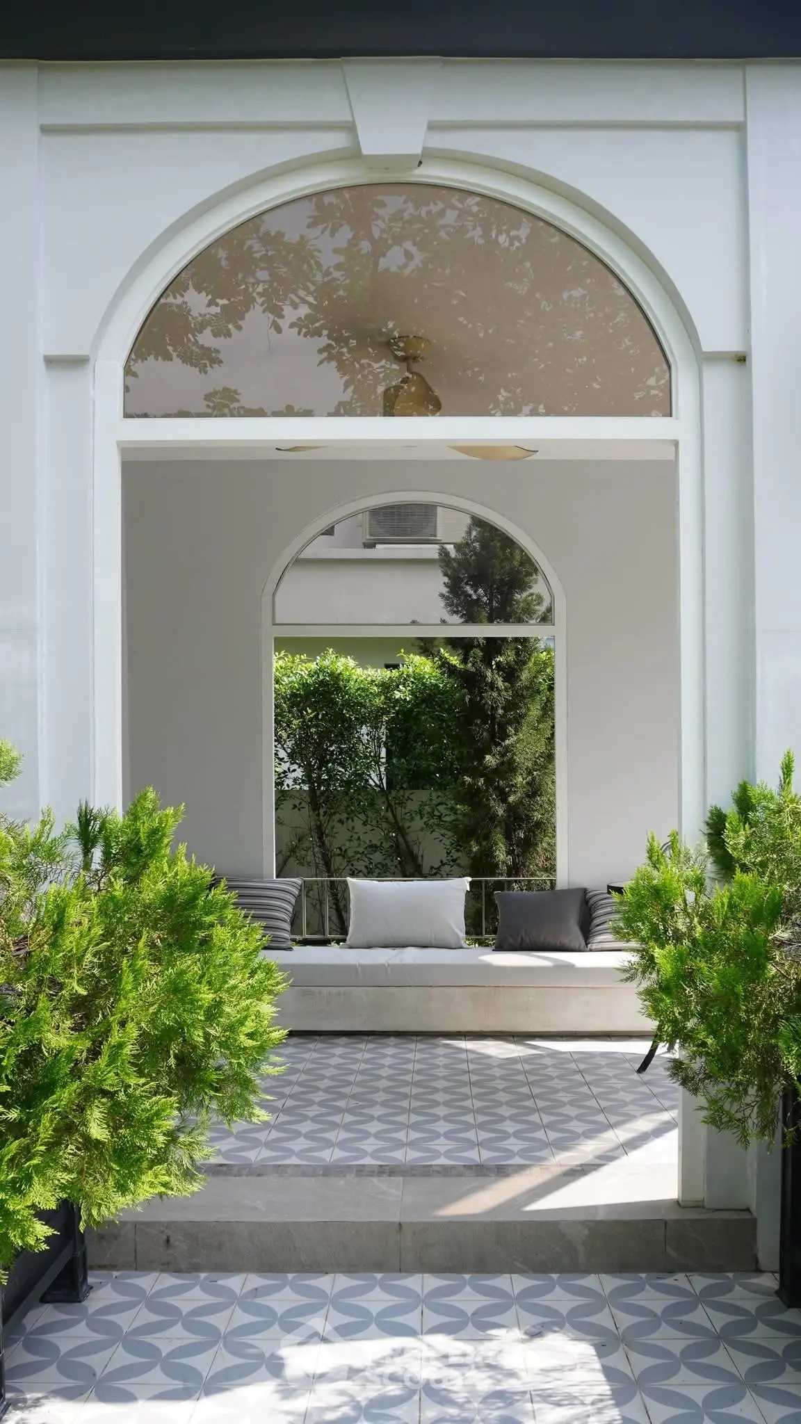 Elegant garden entrance with stylish archway and lush greenery